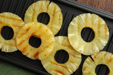Tasty grilled pineapple slices on table, top view