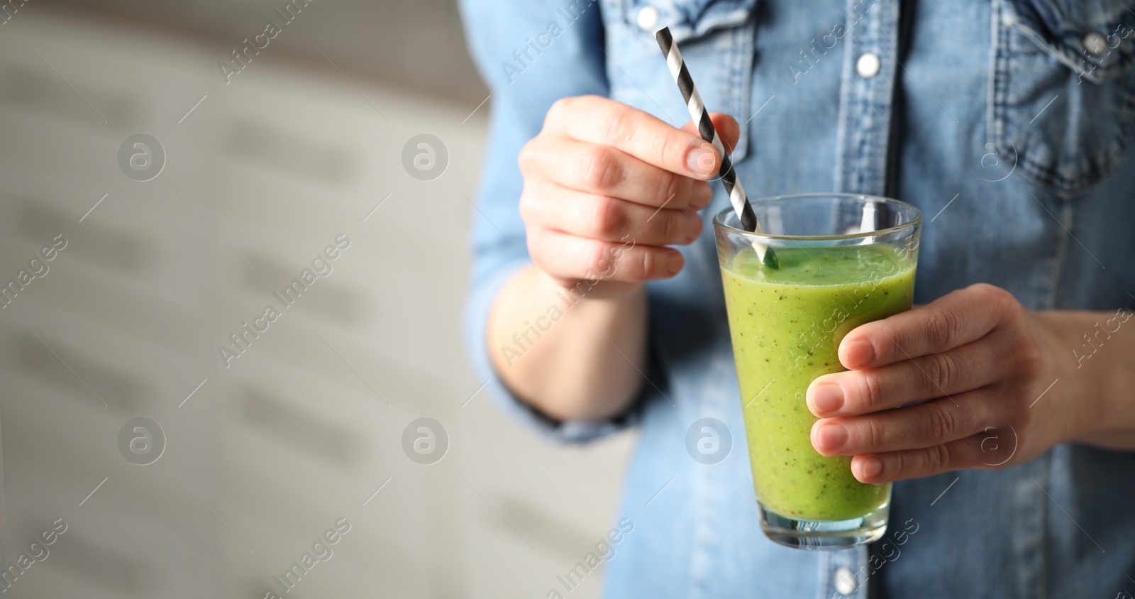 Photo of Woman with delicious kiwi smoothie indoors, closeup. Space for text