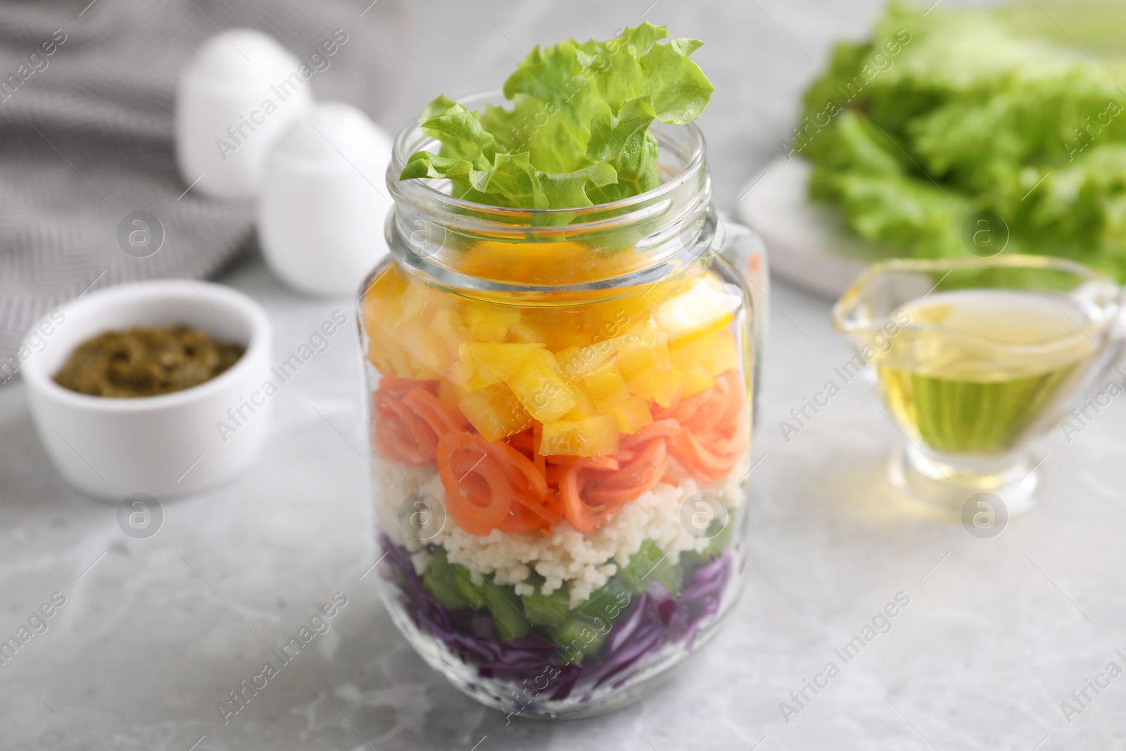 Photo of Healthy salad in glass jar on marble table