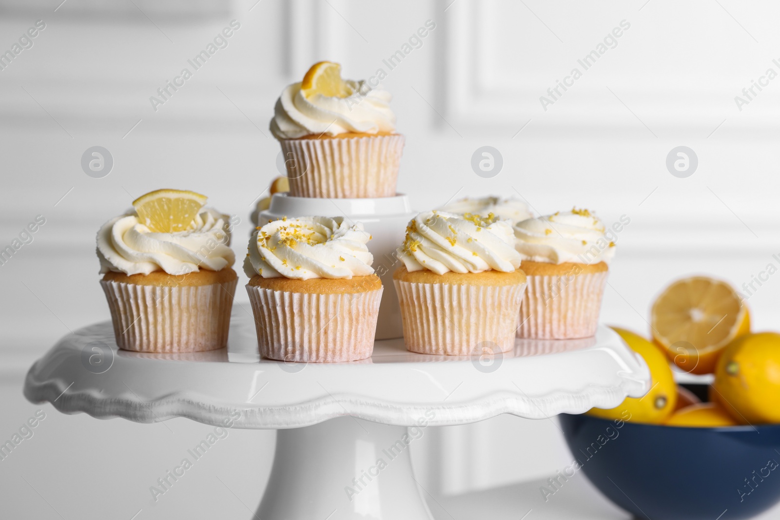 Photo of Delicious lemon cupcakes with white cream on table, closeup