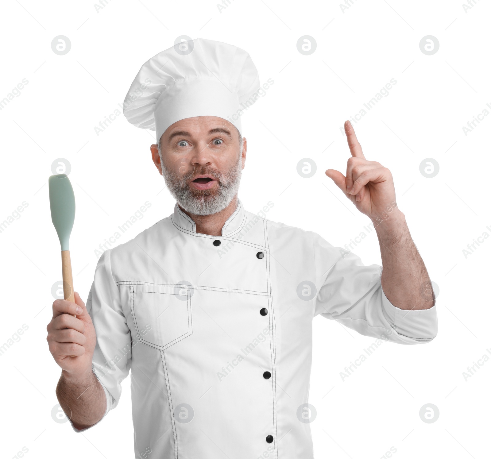 Photo of Surprised chef in uniform with spatula pointing at something on white background