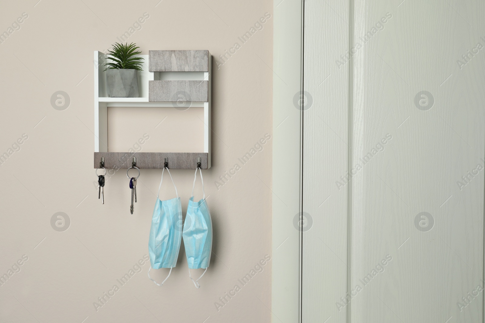 Photo of Wooden hanger for keys on beige wall