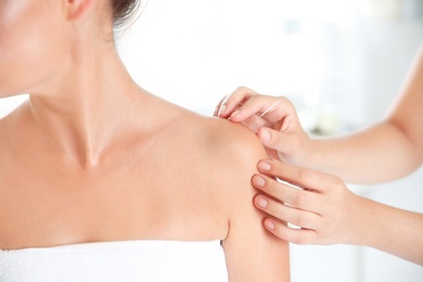 Photo of Young woman undergoing acupuncture treatment in salon, closeup