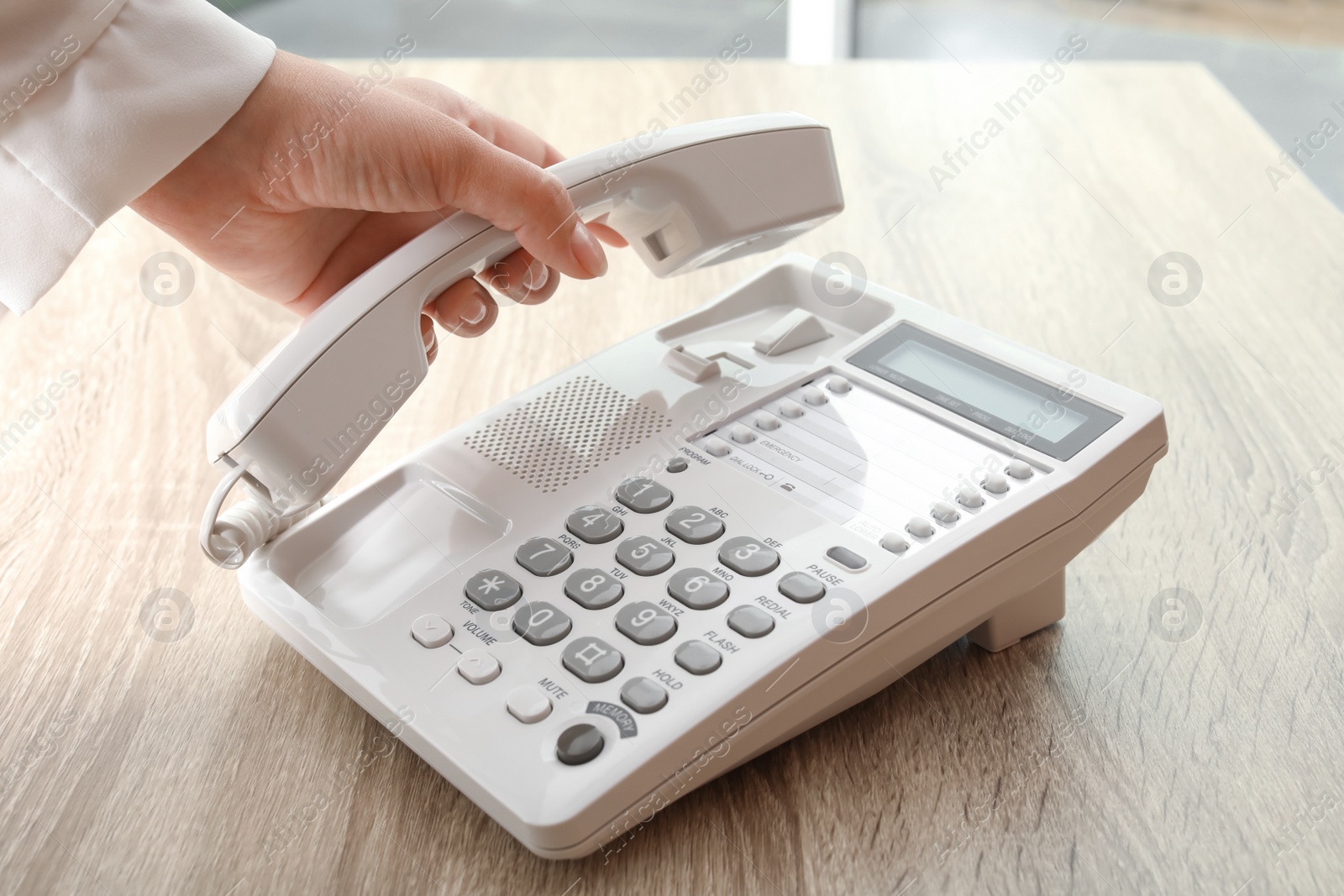 Photo of Woman using telephone at table indoors, closeup