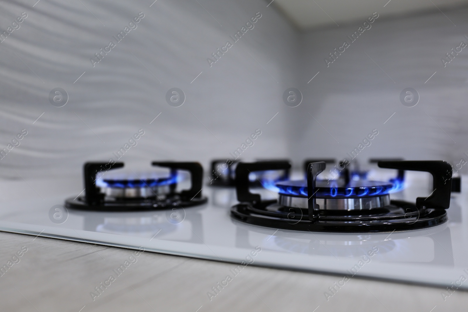 Photo of Modern kitchen stove with burning gas indoors