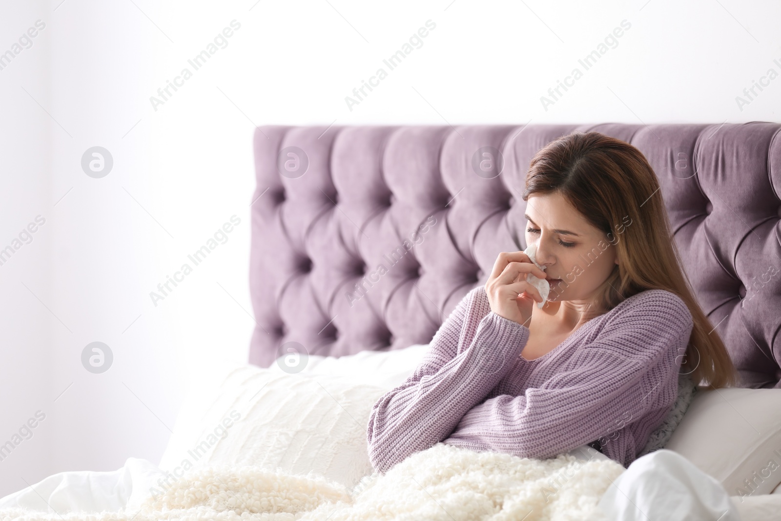 Photo of Sad sick woman with tissue suffering from cold in bed