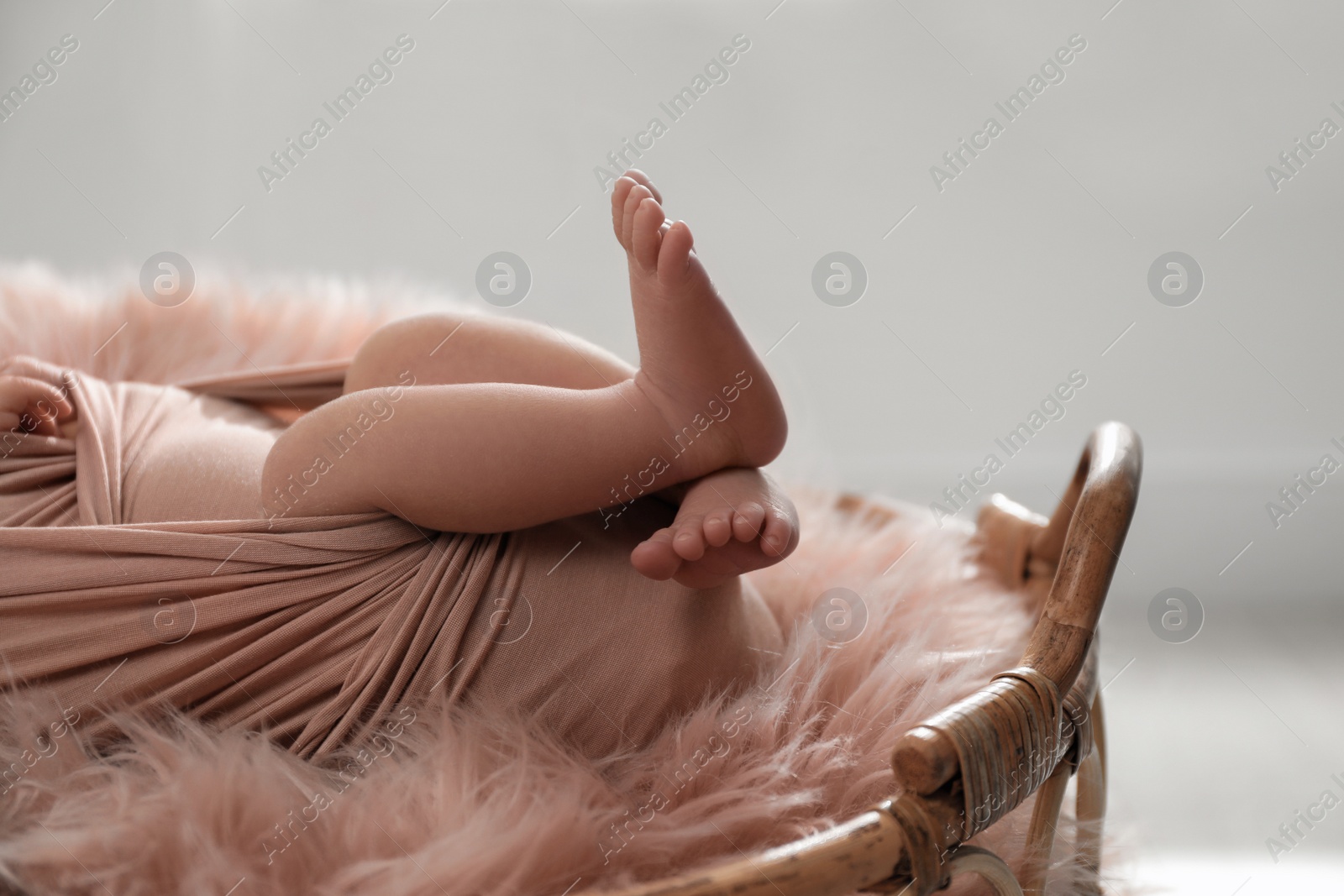 Photo of Newborn baby lying in wicker basket, closeup