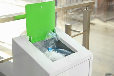 Photo of Metal bin with garbage indoors. Waste recycling