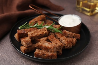 Photo of Crispy rusks with rosemary and sauce on grey table