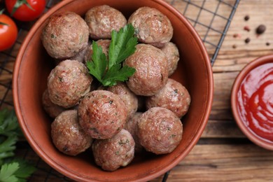 Photo of Tasty cooked meatballs with parsley on wooden table, flat lay