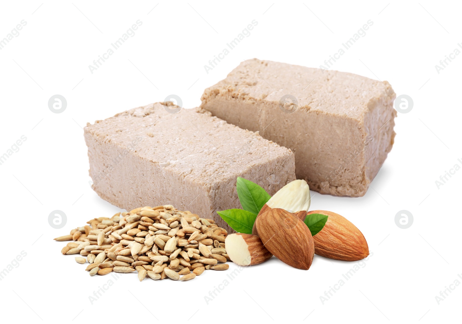 Image of Tasty halva, peeled sunflower seeds, almonds and green leaves isolated on white