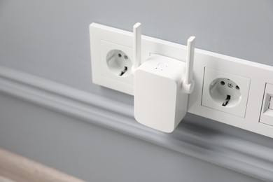 Photo of Wireless Wi-Fi repeater on light grey wall