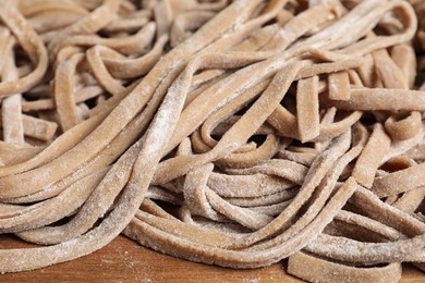 Uncooked homemade soba on wooden board, closeup