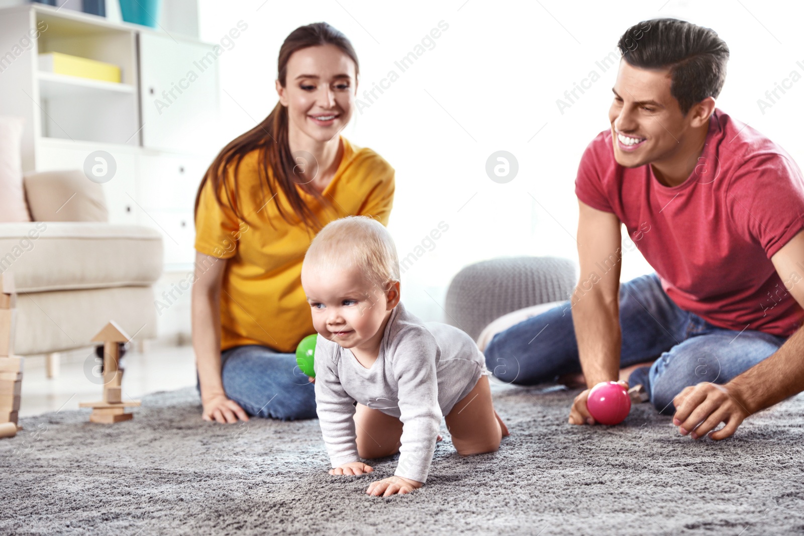 Photo of Adorable little baby crawling near parents at home