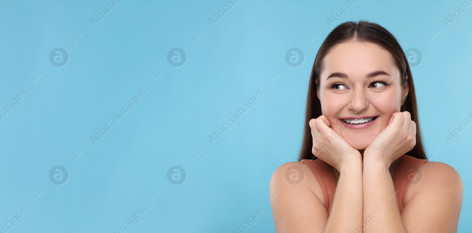 Image of Smiling woman with braces on light blue background. Banner design with space for text