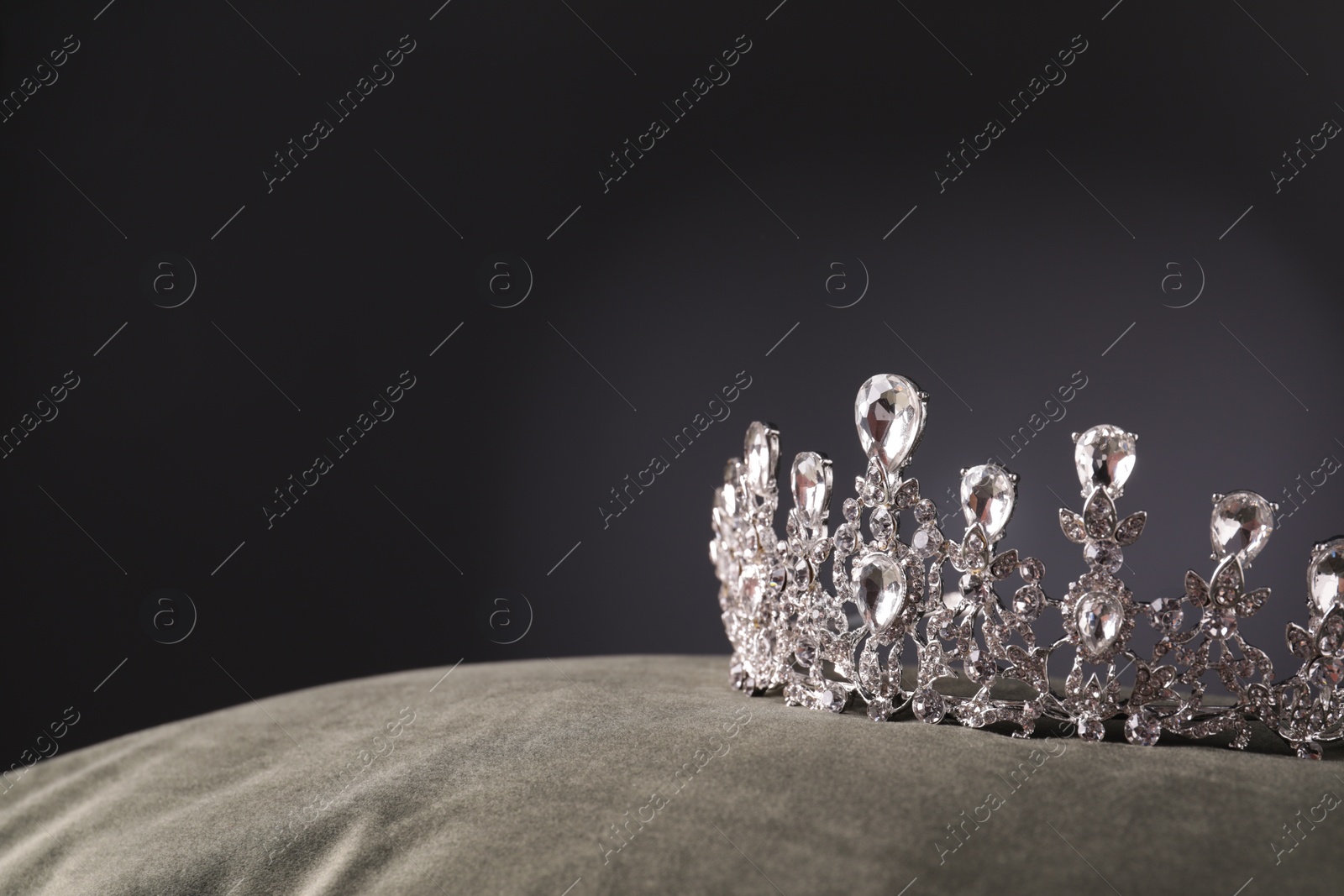 Photo of Beautiful silver tiara with diamonds on grey cloth. Space for text