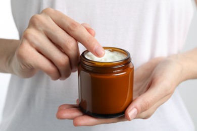 Woman holding jar of hand cream, closeup