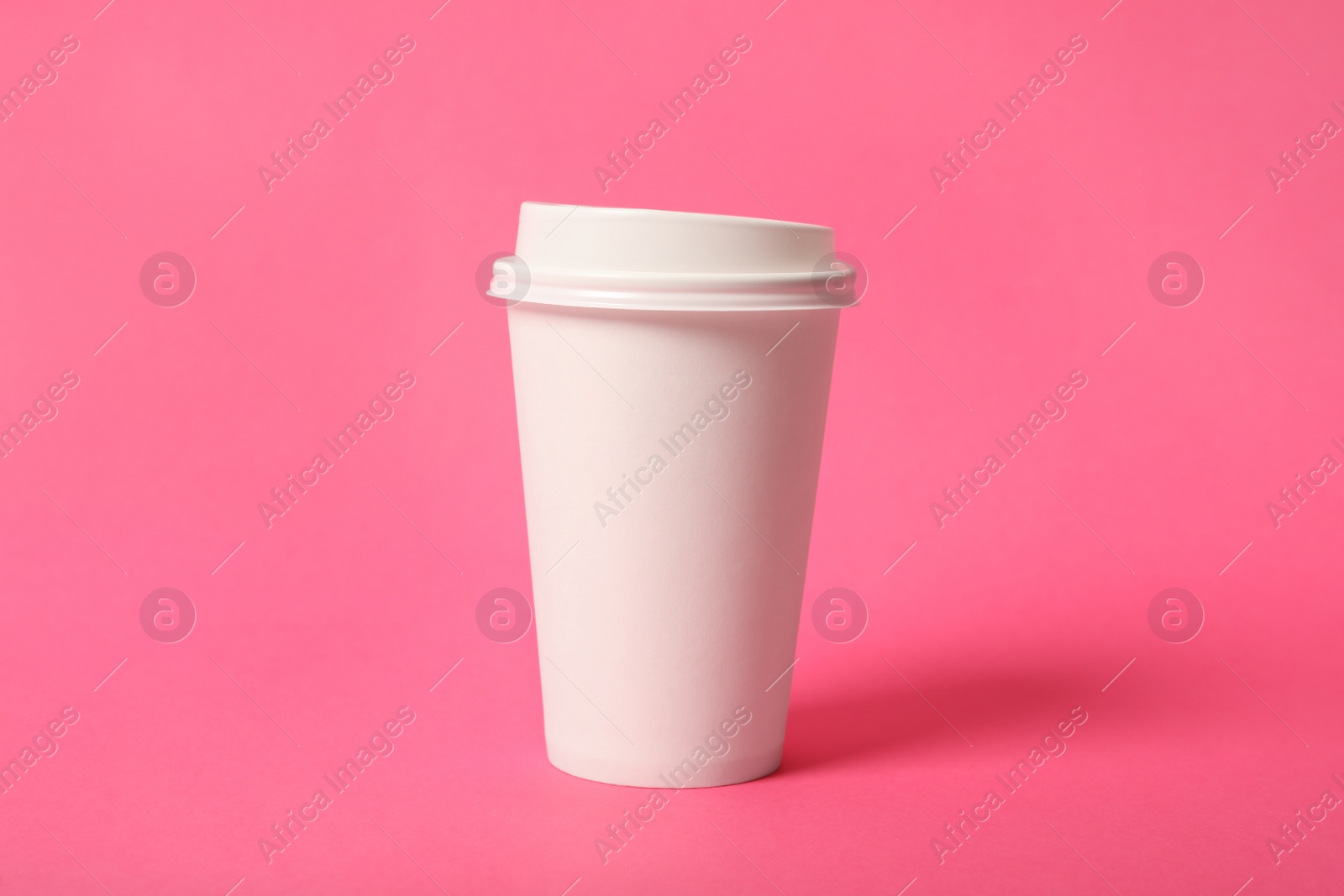 Photo of Takeaway paper coffee cup on pink background