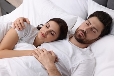 Lovely couple sleeping together in bed at home