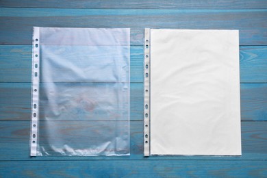 Photo of Punched pockets on light blue wooden table, flat lay. Space for text