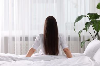 Photo of Woman on bed at home, back view. Lazy morning