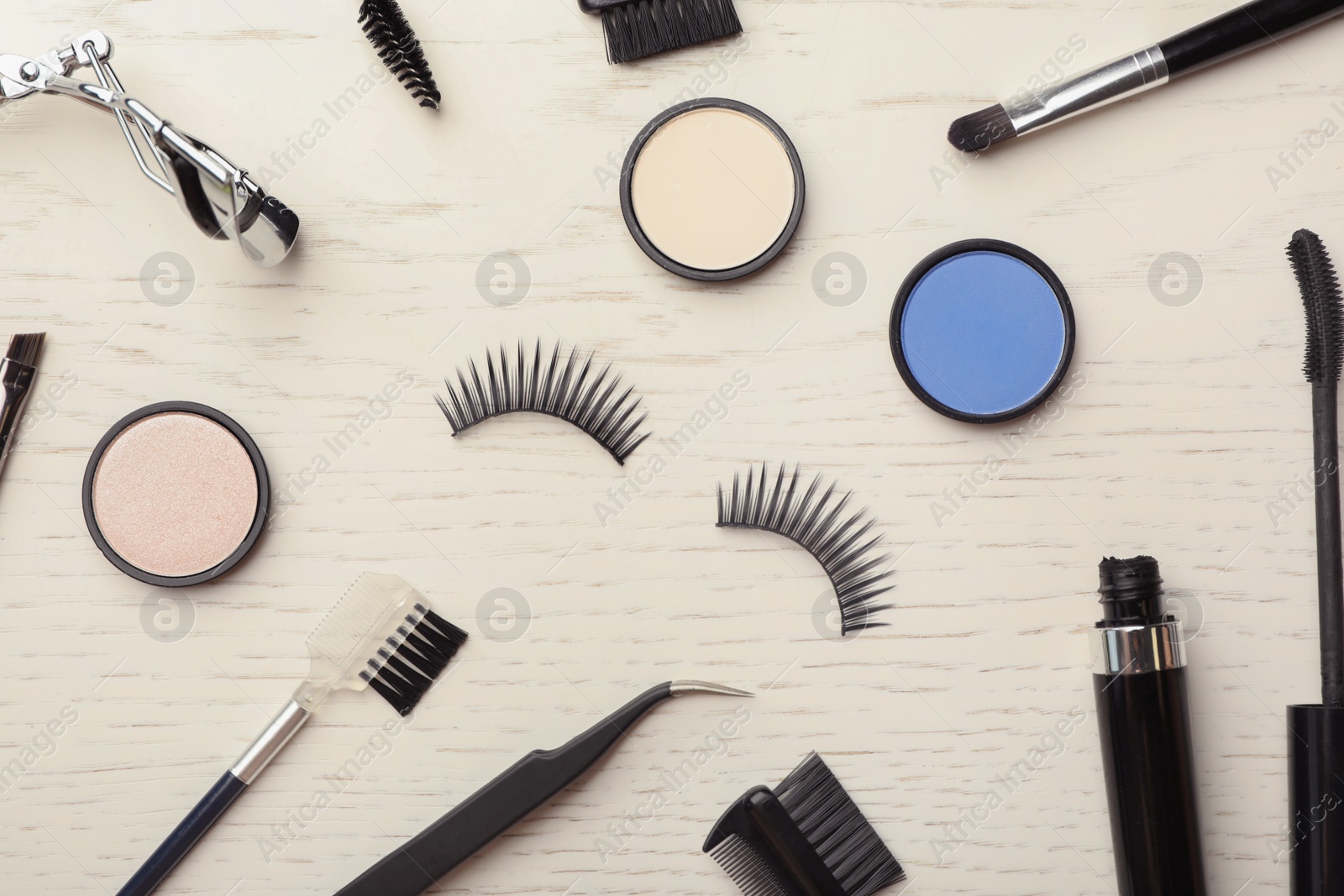 Photo of Flat lay composition with artificial eyelashes and accessories on wooden background