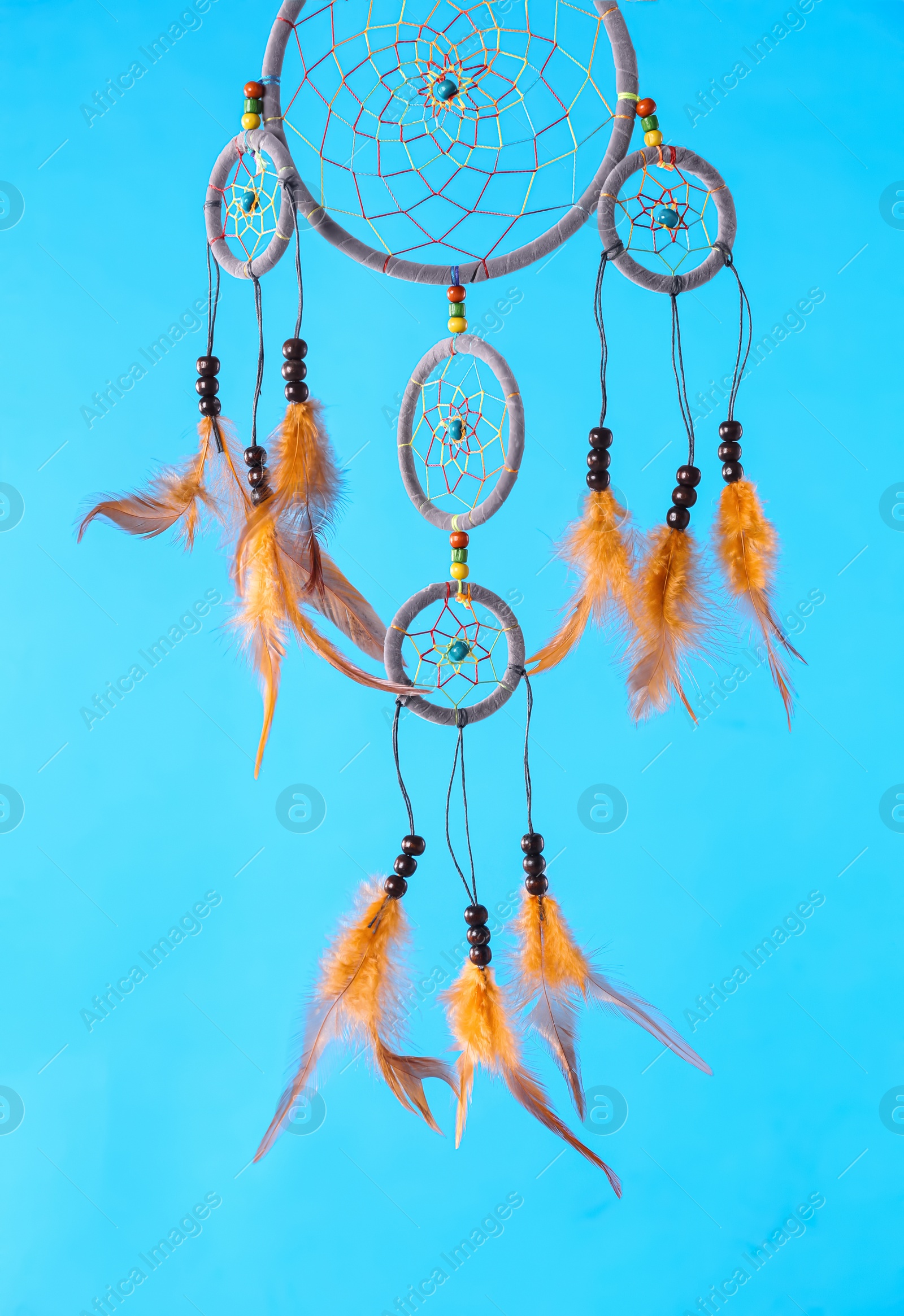 Photo of Beautiful handmade dream catcher on light blue background