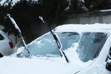 Photo of Car windshield with wiper blades cleaned from snow outdoors on winter day