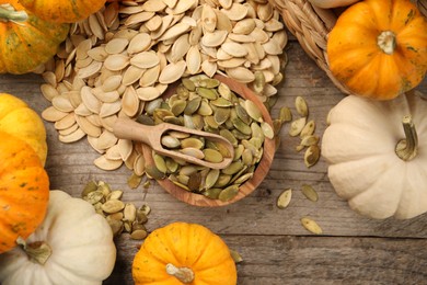 Photo of Many fresh pumpkins and seeds on wooden table, flat lay