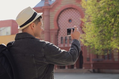 Photo of Tourist taking picture on beautiful city street