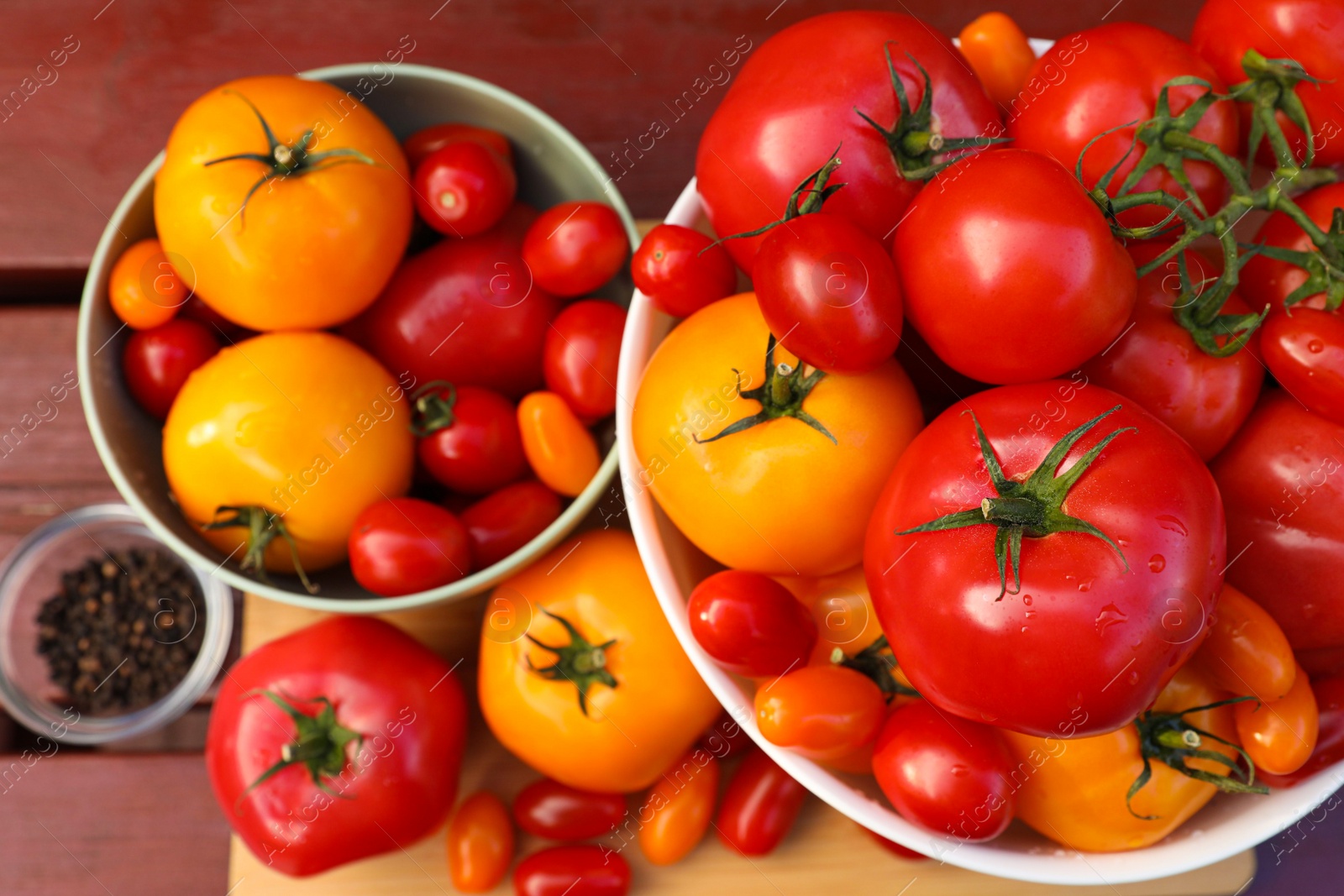 Photo of Bowls with fresh tomatoes and spices on wooden table, flat lay