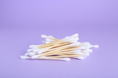 Photo of Many wooden cotton buds on violet background