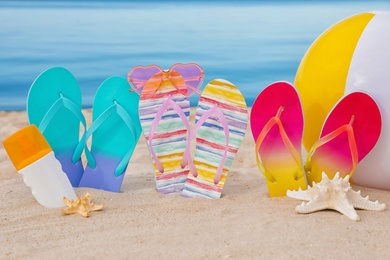 Photo of Sandy beach with different beach accessories near sea. Summer vacation