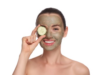 Photo of Beautiful woman with clay mask covering eye with piece of cucumber on white background