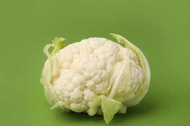 Photo of Whole fresh raw cauliflower on green background