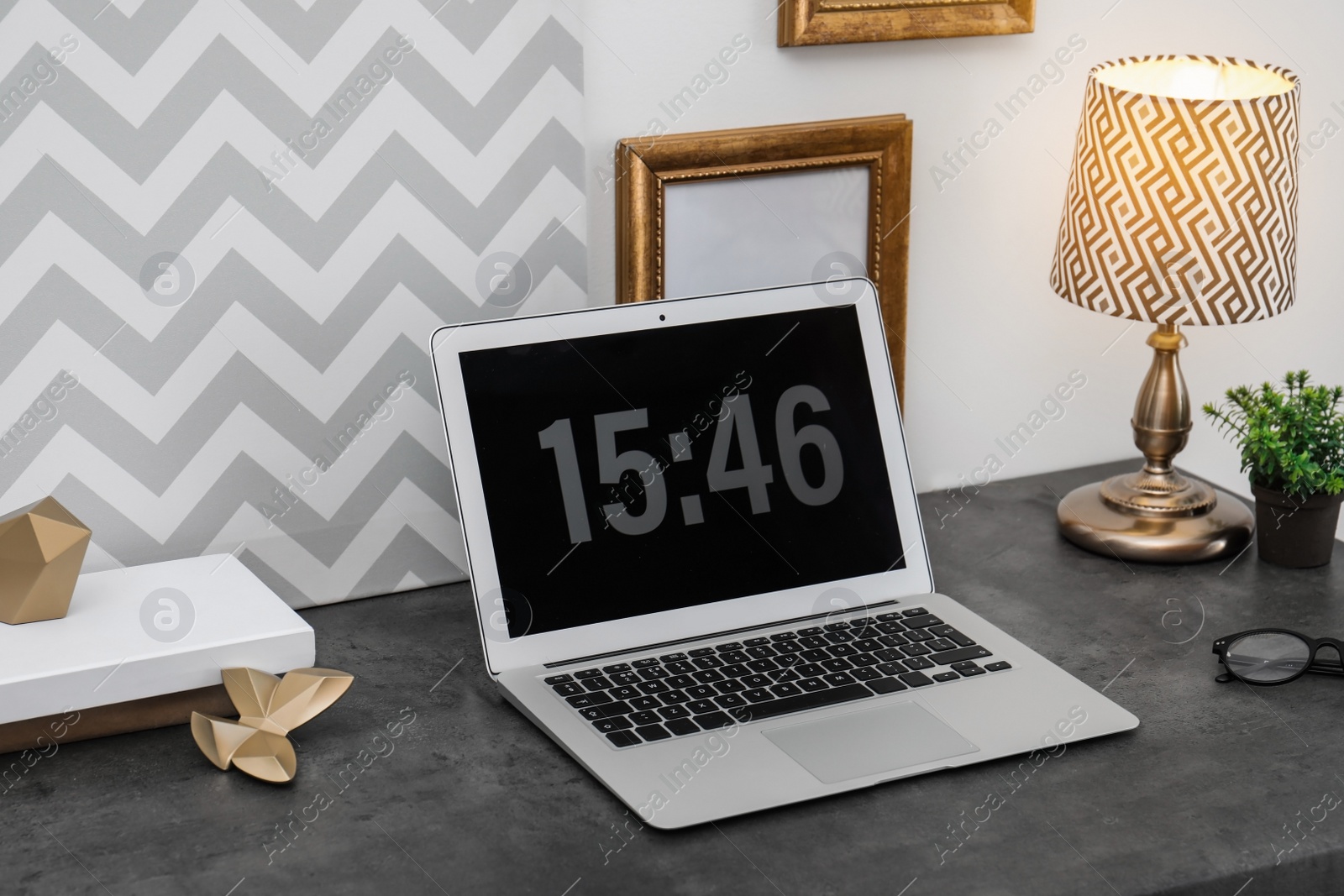 Photo of Stylish workplace with modern laptop on table indoors