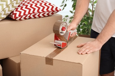 Man packing carton box indoors, closeup. Moving day