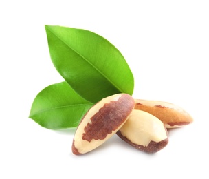 Photo of Brazil nuts with green leaves on white background