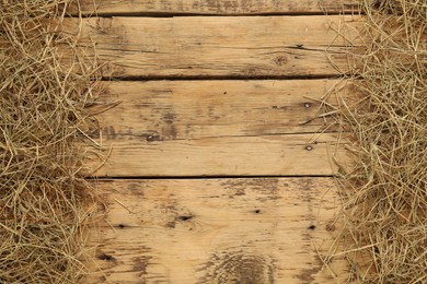 Photo of Dried hay on wooden background, flat lay. Space for text