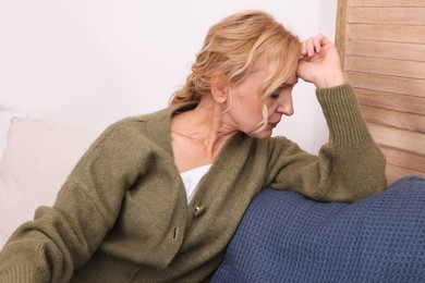 Photo of Upset middle aged woman sulking on sofa at home. Loneliness concept
