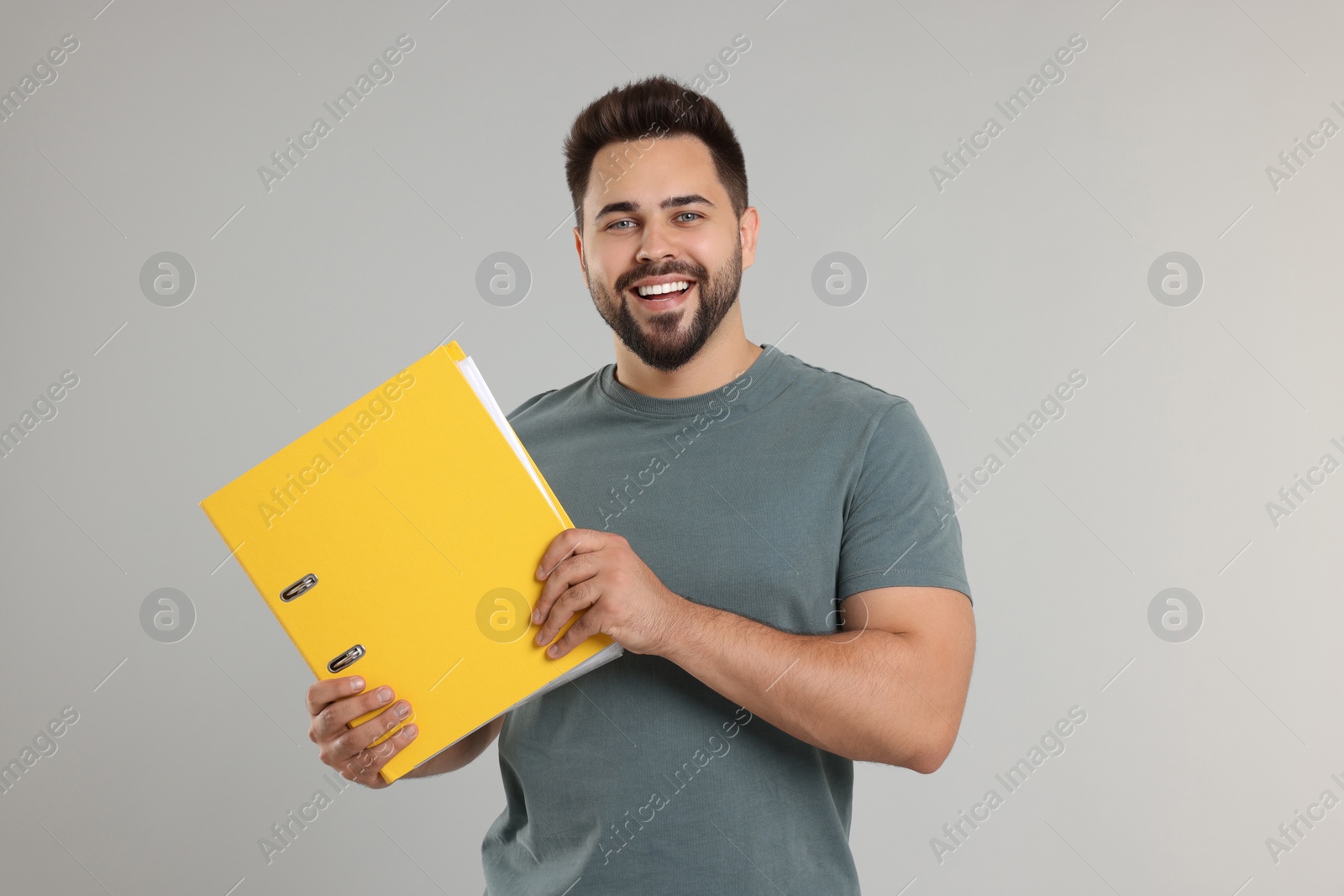 Photo of Happy man with folder on light gray background