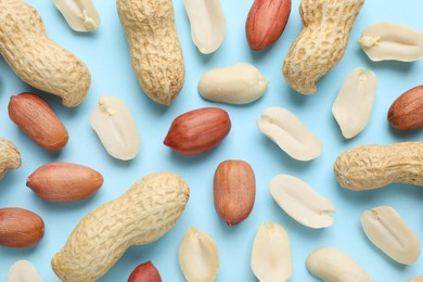 Fresh peanuts on light blue background, flat lay