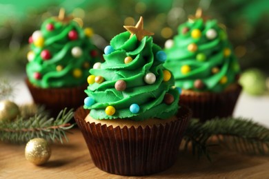 Photo of Tasty Christmas cupcakes on wooden board, closeup