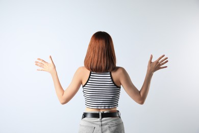 Photo of Girl wearing striped top on white background, back view