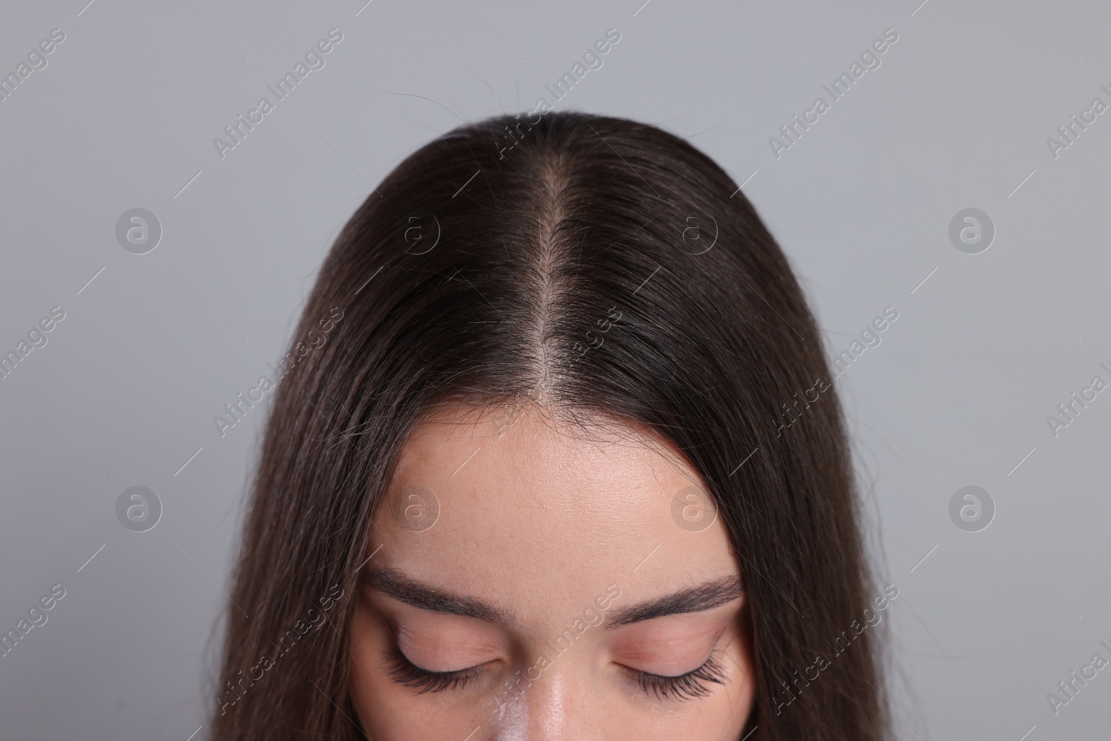 Photo of Woman with healthy hair on grey background, closeup