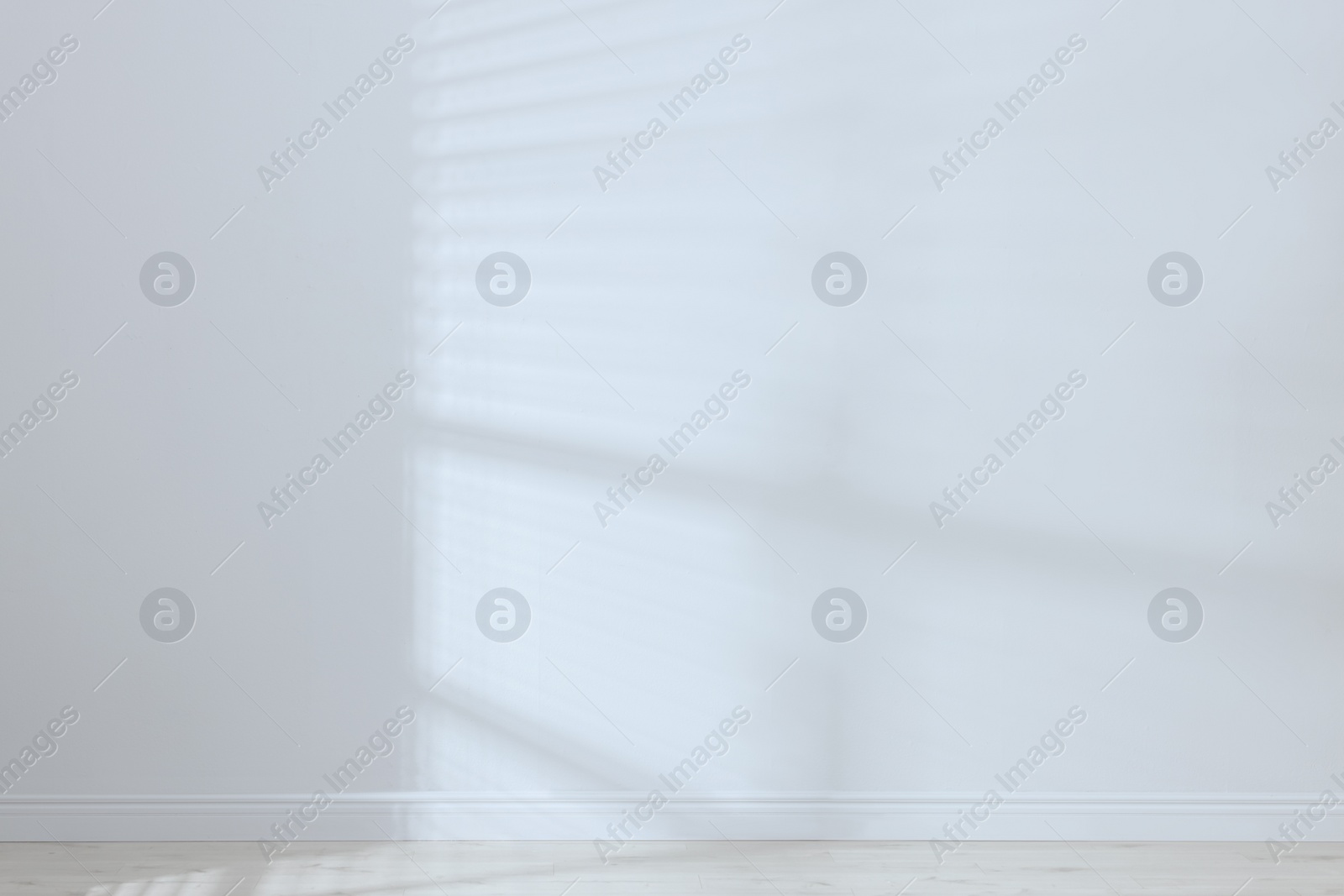 Photo of Empty room with white wall and wooden floor