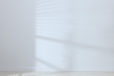Photo of Empty room with white wall and wooden floor