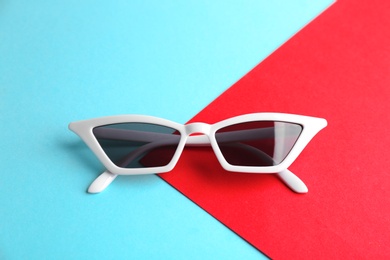 Photo of Stylish sunglasses on color background. Summer time