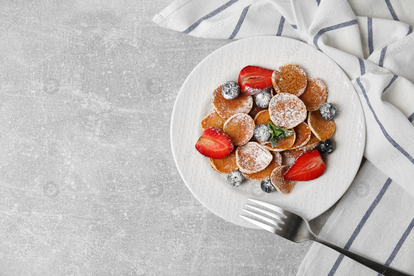 Photo of Cereal pancakes with berries served on light grey table, flat lay. Space for text