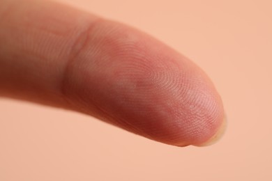 Closeup view of woman's finger on beige background